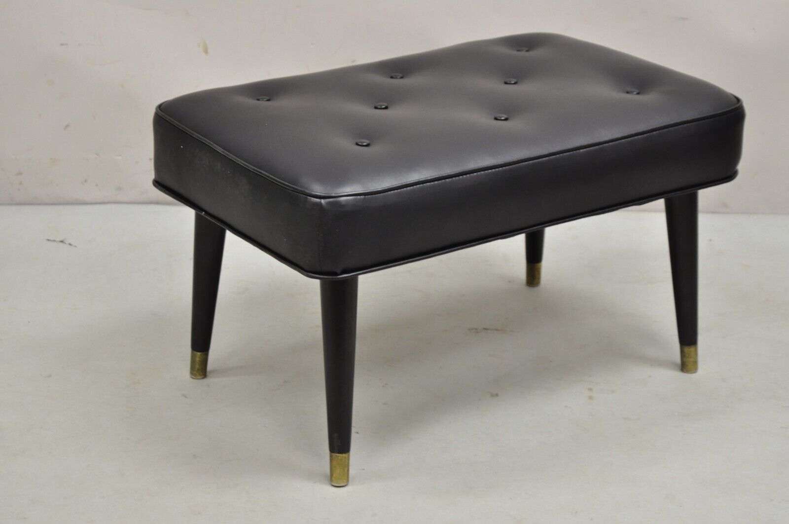 Vintage Mid Century Modern Black Tufted Vinyl Tapered Leg Footstool Ottoman