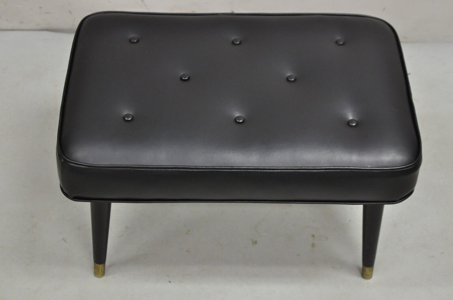 Vintage Mid Century Modern Black Tufted Vinyl Tapered Leg Footstool Ottoman